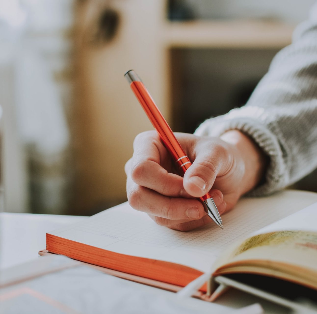 A hand writing in a notepad