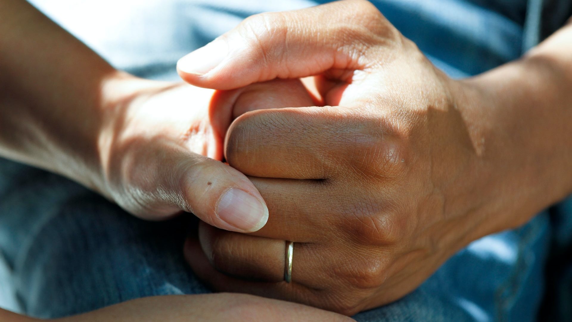 Close up of two people holding hands supportively
