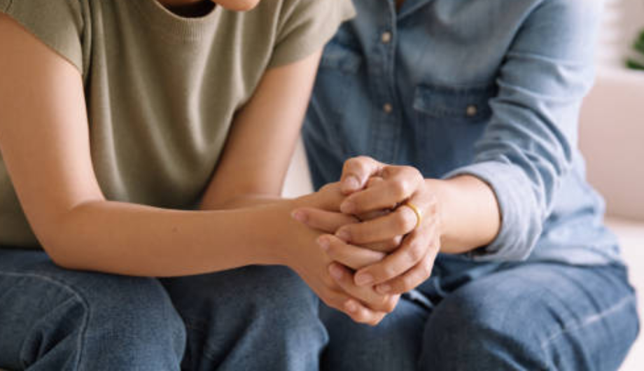 two people holding hands supportively