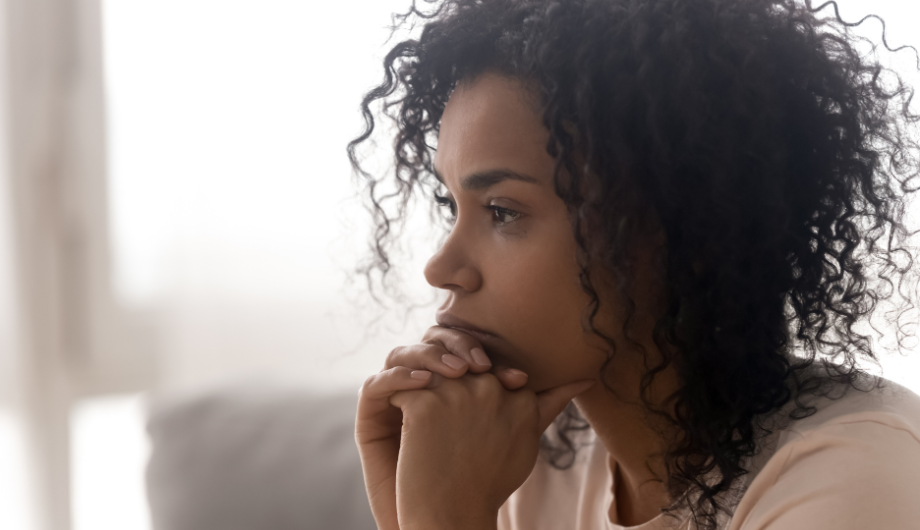 Zoomed in image of a woman's head, her facial expression shows thought.