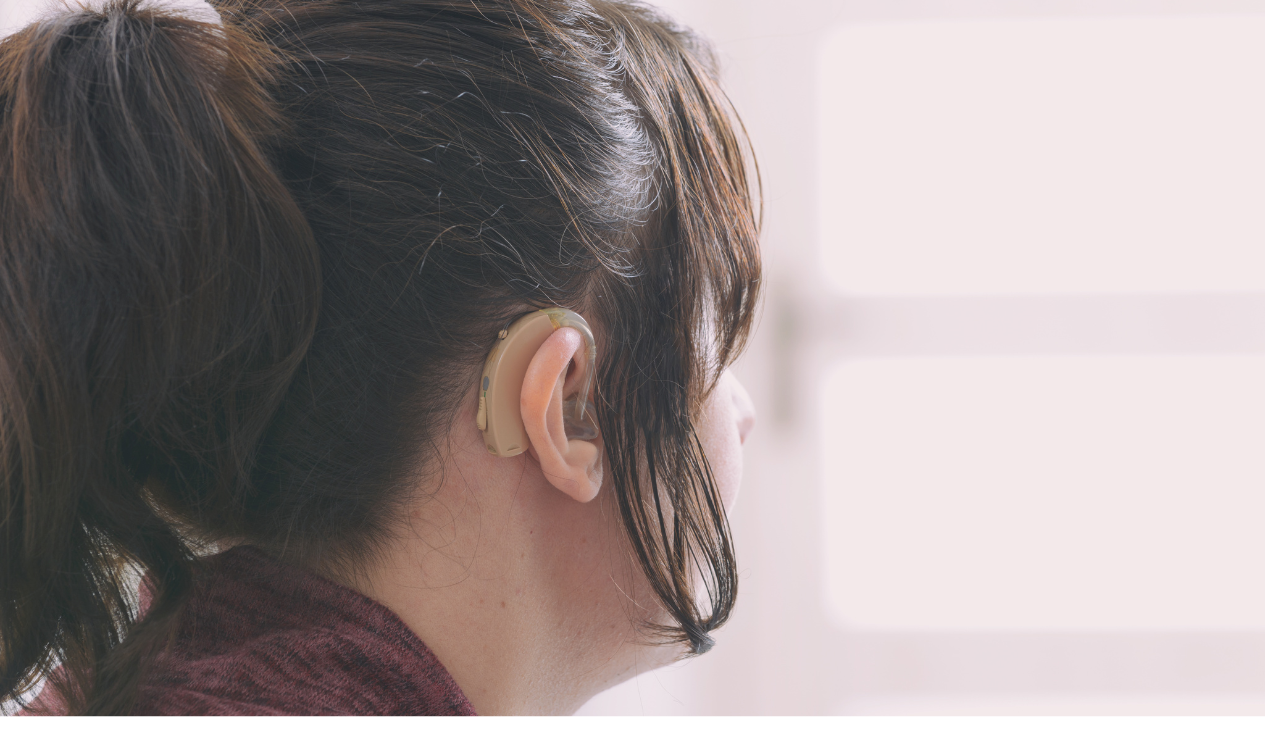 A woman wearing a hearing aid, facing away from camera