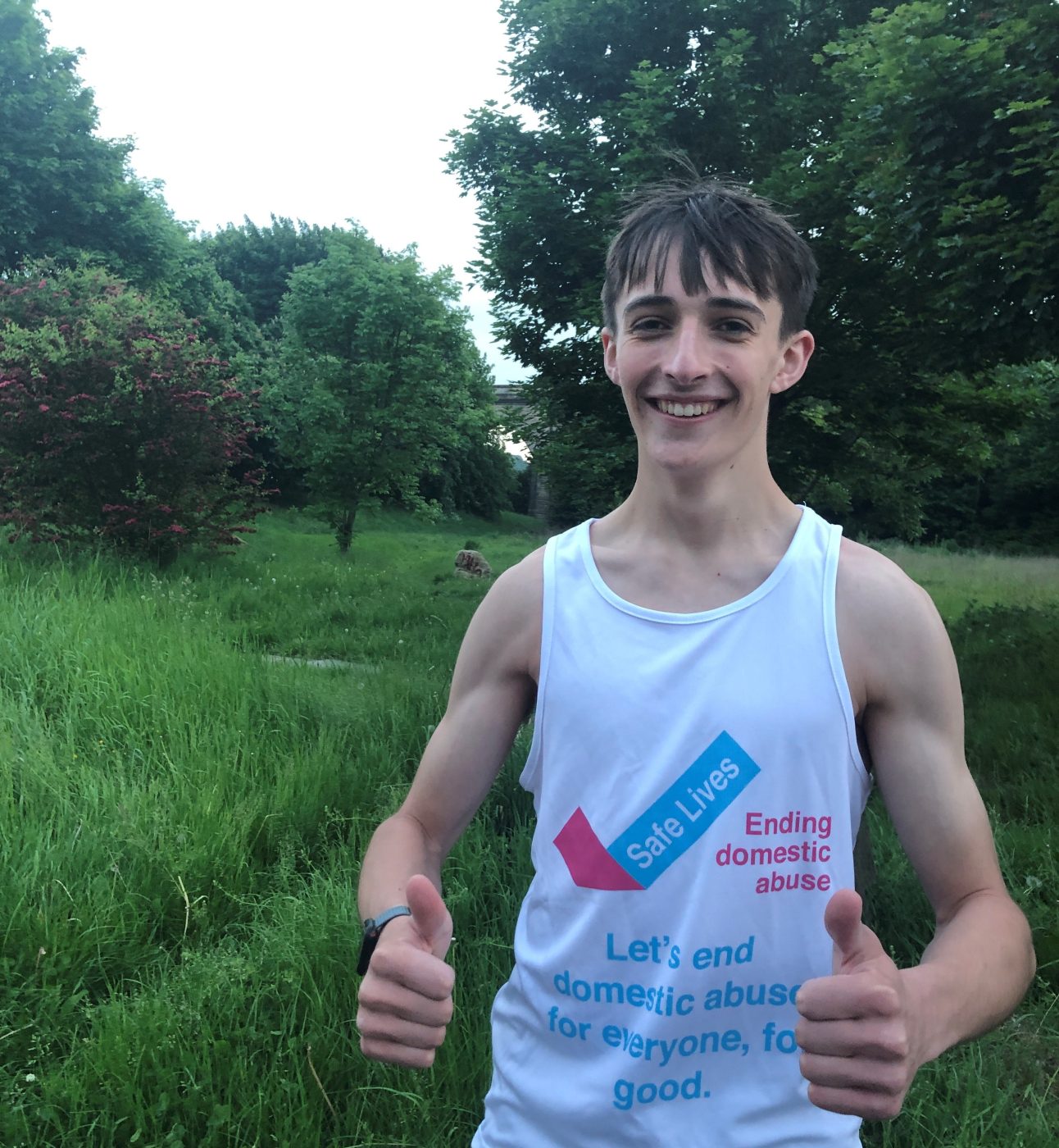 A young man wearing a SafeLives fundraising T-shirt